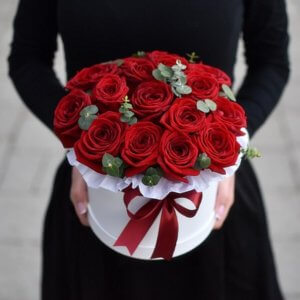 Red roses with eucalyptus flowers in a box