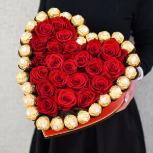 Raudonos rožės ir saldainiai dėžutėje gėlės merginai valentino dienai